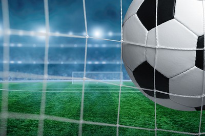 Close Up of Football Hitting Net from Behind Goal