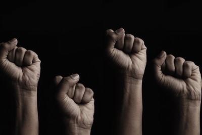 Fists Raised in Air Against Black Background