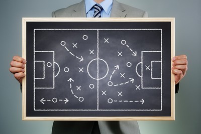 Football Manager Holding Up Tactics Board