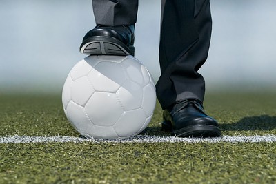 Football Manager Standing with Ball by Pitch