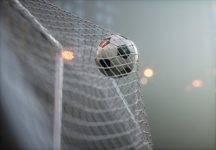 Football in Goal Against Blurred Grey Background