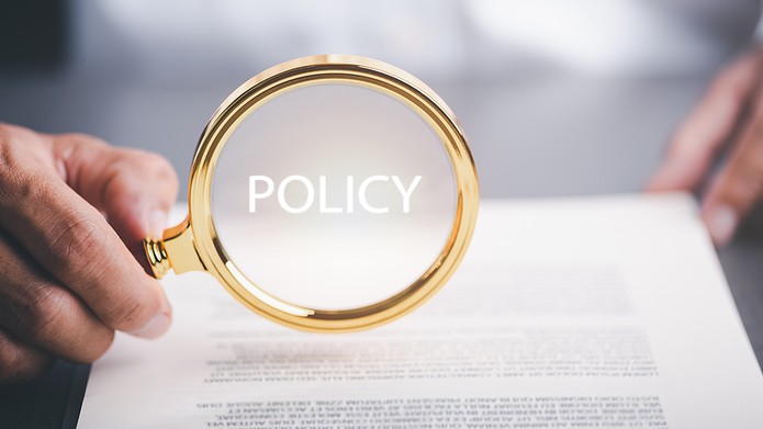 Gold Policy Magnifying Glass Above Page of Text