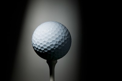 Golf Ball on Tee Under Spotlight