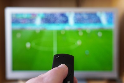 Hand Pointing Remote at Football on TV