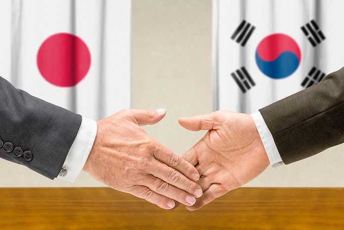 Handshake Against Flags of Japan and South Korea