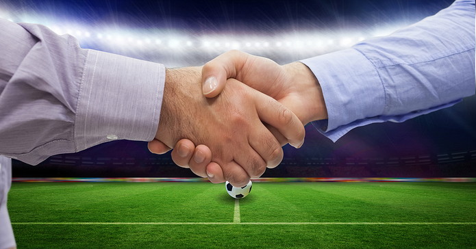 Handshake In Front of Football Pitch