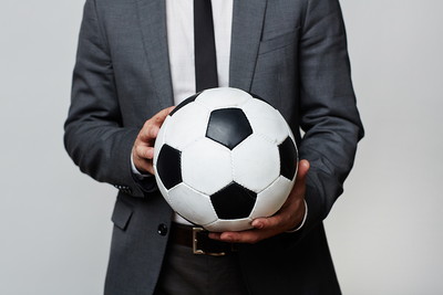 Man in Grey Suit Holding Football