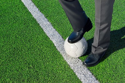 Man in Suit Standing on Football