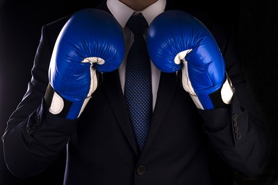 Man in Suit Wearing Blue Boxing Gloves