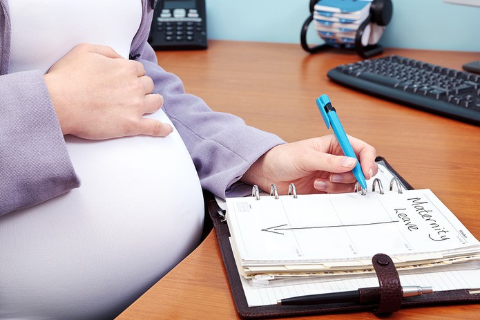 Pregnant Woman Writing Maternity Leave in Diary