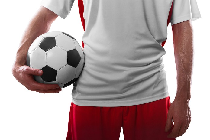 Mid Section of Footballer Holding Ball