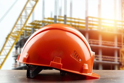 Orange Safety Helmet Against Structure