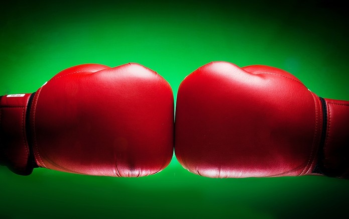 Red Boxing Gloves Against Green Background