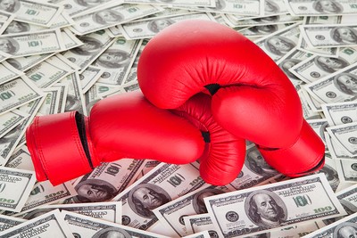 Red Boxing Gloves on Pile of 100 Dollar Bills
