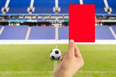Red Card Held Against Blue Stadium Seats