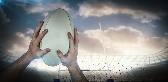 Pemain Rugby Menangkap Bola Melawan Langit Cerah