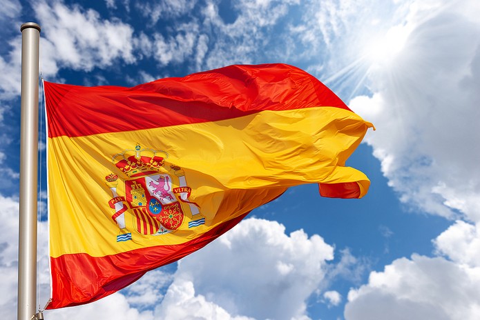 Spain Flag Waving Against Sunny Cloudy Sky