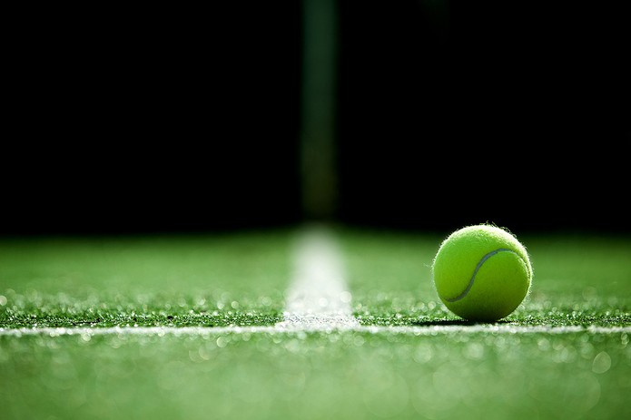 Tennis Ball on Court Against Dark Background