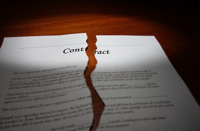 Torn Contract on Wooden Desk