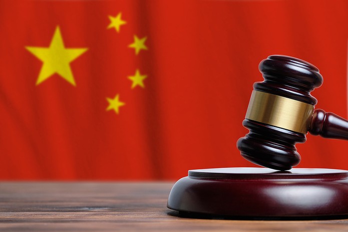Wooden Gavel In Front Of Chinese Flag